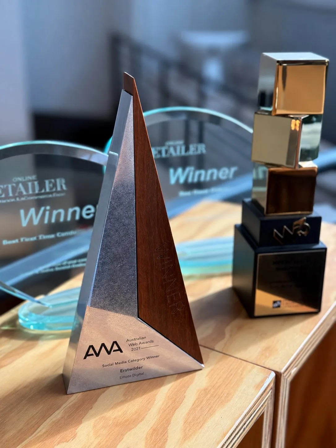 An Australian Web Awards trophy with Online Retailer and W3 Awards behind.